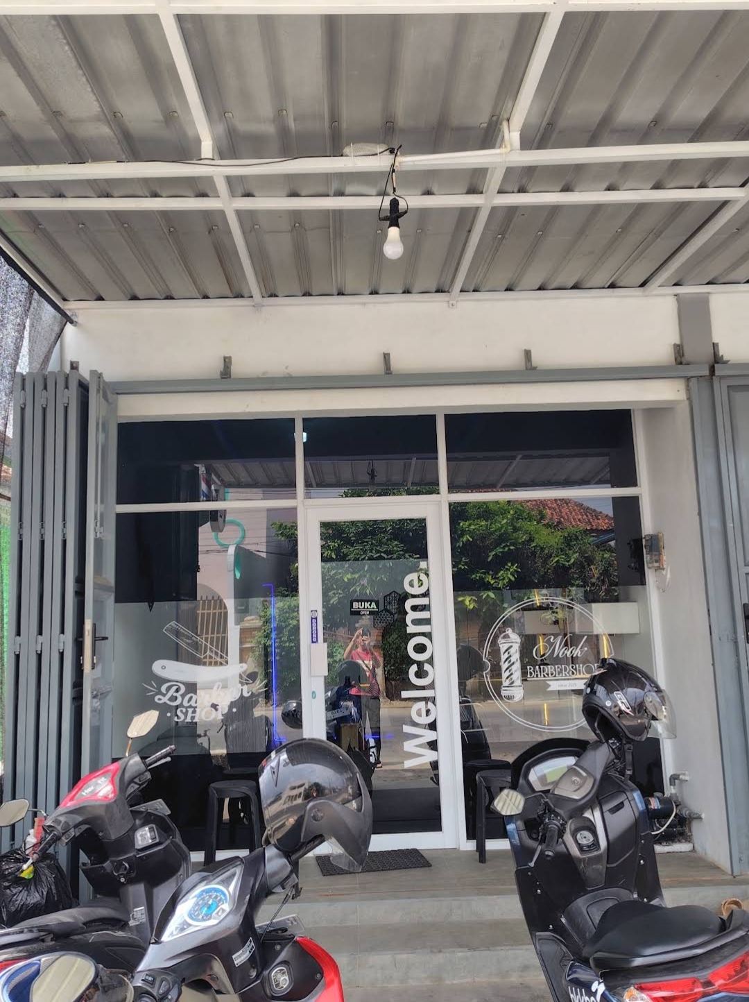 Tampak depan NOOK Barbershop dengan sepeda motor terparkir.